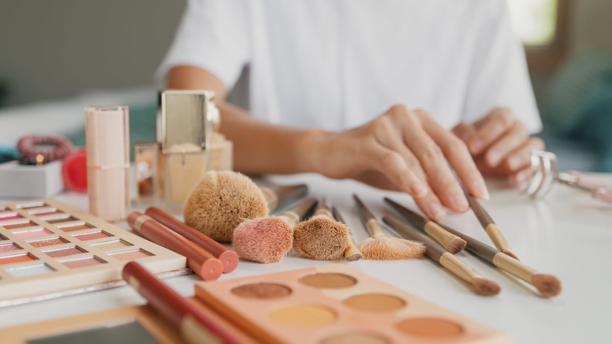 Detalle de productos de maquillaje y cuidado facial con brochas